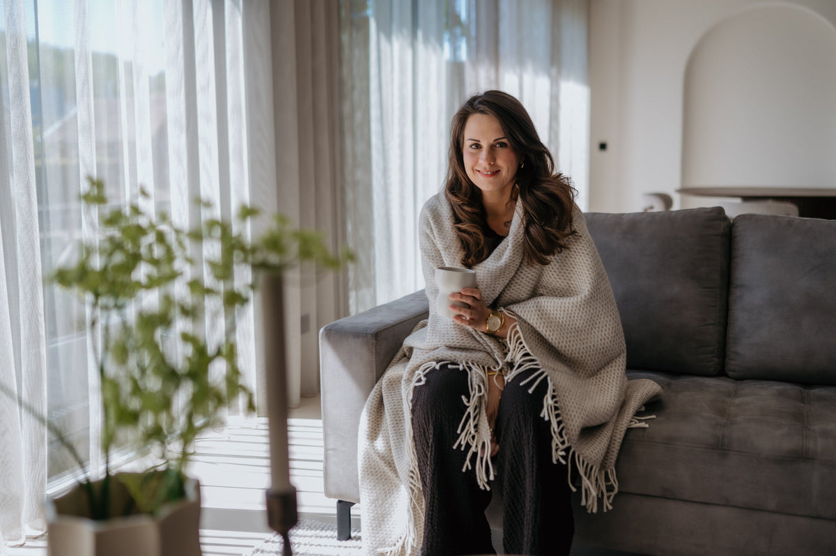 Wollen plaid op de bank beige